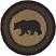 Invite a rustic lodge look to your meals with the Wyatt Bear Jute Trivet. A black bear is stenciled the center over solid dark tan surrounded by concentric braids of black, crimson, and army green.